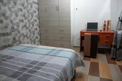 a bedroom with a bed and a desk with a laptop at Apartamento La Merced in La Merced