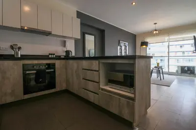 a kitchen with a stove and a microwave at Stelar by Wynwood House in Lima