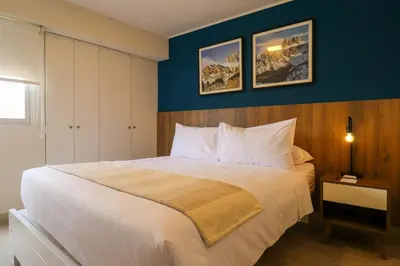 a bedroom with a large white bed with blue walls at Stelar by Wynwood House in Lima