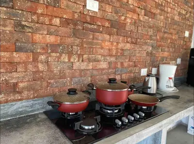 two pots and pans on a stove with a brick wall at Casa Tullpa in Aspitia