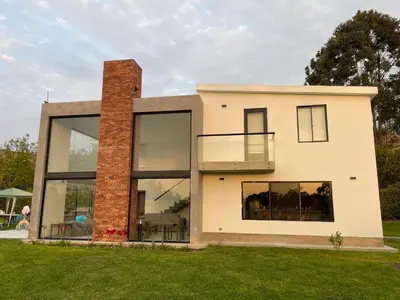 a house with large windows and a brick chimney at Casa Tullpa in Aspitia