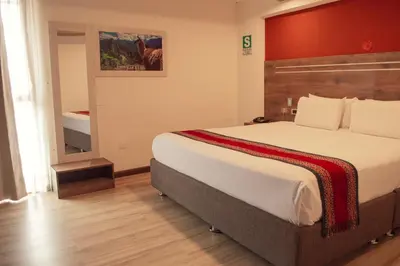a hotel room with a large bed and a bathroom at INKALAM cusco in Cusco