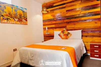a bedroom with a bed with a wooden wall at Hotel SumacPlaza in Ayacucho