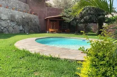a swimming pool in the middle of a yard at Casa Cusco in Cieneguilla