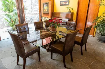a dining room with a glass table and chairs at Casa Cusco in Cieneguilla
