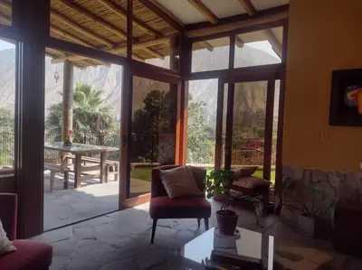 a living room with a large glass door to a patio at Casa Cusco in Cieneguilla