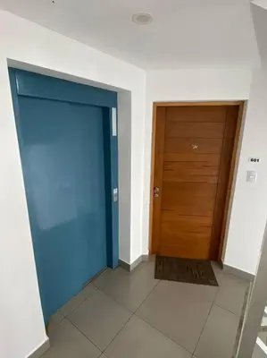 a hallway with a blue door and a wooden door at Alojamiento frente al mar en San Bartolo in San Bartolo
