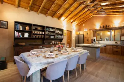 a dining room with a table and chairs and a kitchen at Casa Tikawarmi in Urubamba