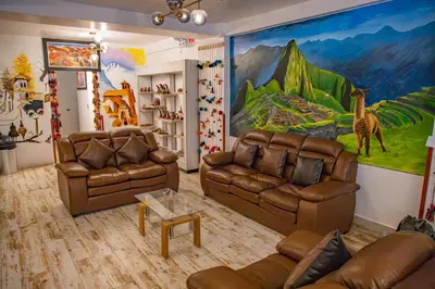 a living room with two couches and a mural at Chakana Hotel Machupicchu in Machu Picchu