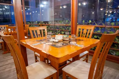 a wooden table and chairs in a restaurant at Chakana Hotel Machupicchu in Machu Picchu