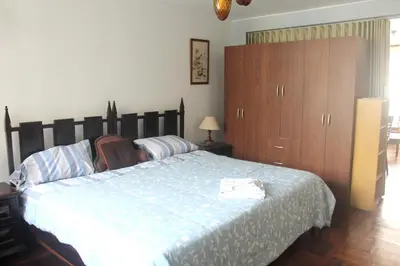 a bedroom with a large bed and wooden cabinets at Palmeras Apartments San Isidro in Lima