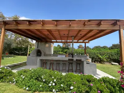 a wooden pergola over a stove in a garden at Casa de campo en Hacienda San Andres in San Andrés