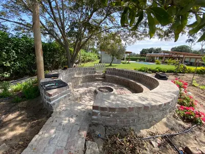 a stone fire pit in a yard with a tree at Casa de campo en Hacienda San Andres in San Andrés