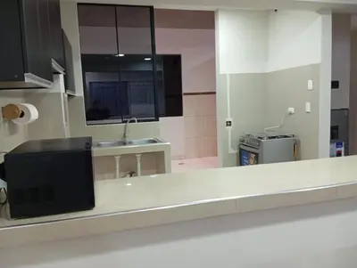 a kitchen with a counter with a sink and a mirror at La campiña in Lima