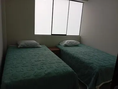 two beds in a small room with a window at La campiña in Lima