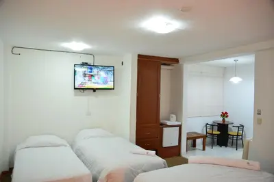 a room with three beds and a tv on the wall at Qallwa Asia in Asia