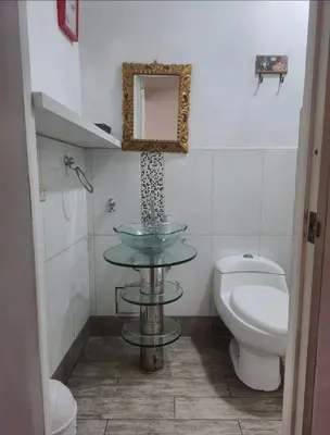 a bathroom with a sink and a toilet and a mirror at Excelente Departamento las viñas in La Molina