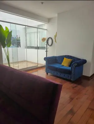 a living room with a blue couch and a window at Excelente Departamento las viñas in La Molina