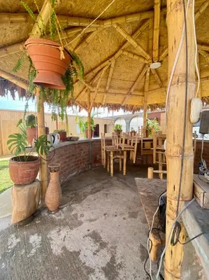 a pavilion with a table and chairs and plants at Coco y Ainhoa Lodge in Paracas