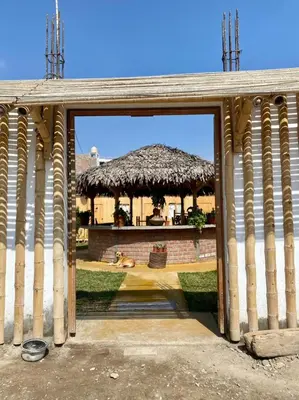 an entrance to a building with a thatch roof at Coco y Ainhoa Lodge in Paracas