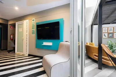 a living room with a couch and a tv on a wall at Stelar Apartments by Vibrant in Lima