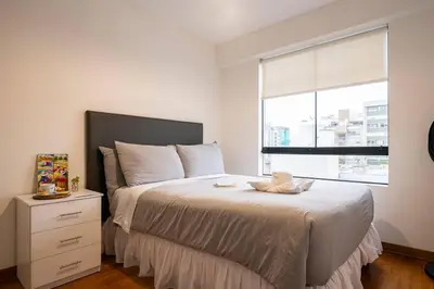 a bedroom with a bed with a dresser and a window at Nogales Family Apartments by Vibrant in Lima