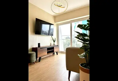 a living room with a tv and a table and a chair at Apartamento Céntrico cerca a San Isidro in Lima