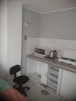 a kitchen with a desk with a microwave and a chair at Microdepartamento amoblado in Lima