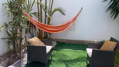 a hammock in a room with chairs and plants at 102 habitacion con baño y cocina e ingreso independiente in Lima
