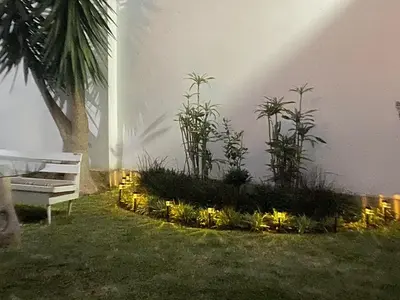 a garden with lights in the grass next to a bench at 102 habitacion con baño y cocina e ingreso independiente in Lima