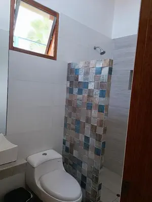 a bathroom with a toilet and a window and a shower at Casa pachacamac in Pachacamac