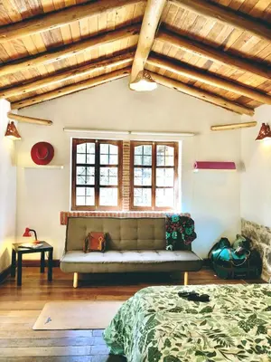 a living room with a couch and a bed at The Tree House in Cusco