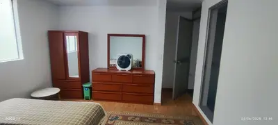 a bedroom with a bed and a dresser with a mirror at Posada Estela in Lima