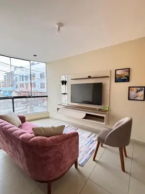 a living room with a couch and a television at Light department in Lima