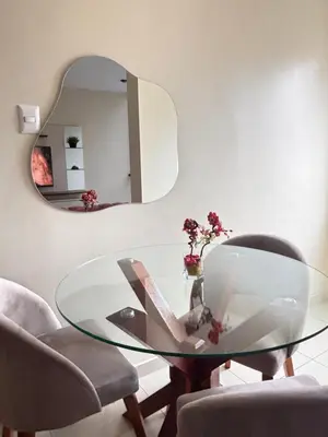a glass table in a room with two chairs and a mirror at Light department in Lima