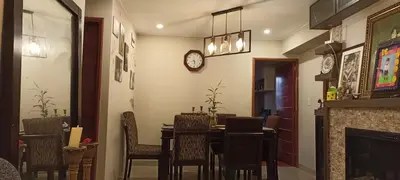a dining room with a table and chairs and a clock at Depa4dormitoriosPuebloLibre in Lima