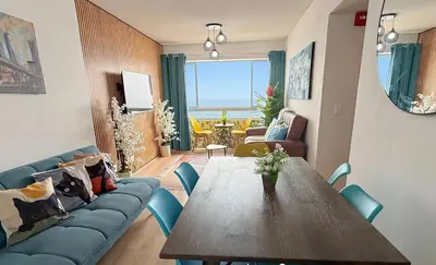 a living room with a table and a blue couch at Exclusivo con vista al mar - Blue One in Lima
