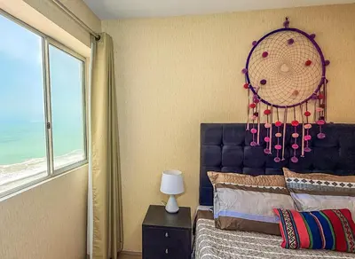 a bedroom with a bed with a blue headboard and a window at Exclusivo con vista al mar - Blue One in Lima