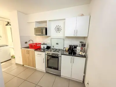 a kitchen with white cabinets and a stove top oven at Exclusivo con vista al mar - Blue One in Lima