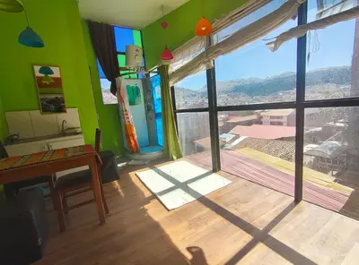 a living room with a green wall and a window at IG Art in Cusco