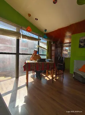 a man sitting at a table in a room at IG Art in Cusco