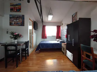 a bedroom with a bed and a table and a desk at IG Art in Cusco