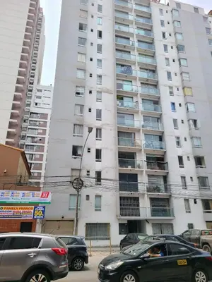 a large white building with cars parked in front of it at Departamento Centenario in Lima