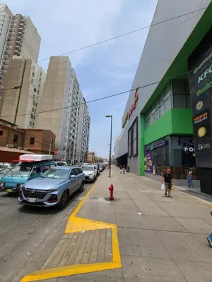 a street with cars parked on the side of the road at Departamento Centenario in Lima