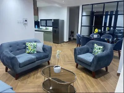 a living room with blue couches and a table at Apartamentos como en casa in Chancay
