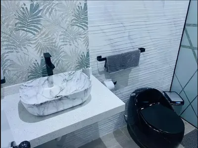 a bathroom with a marble sink and a toilet at Apartamentos como en casa in Chancay