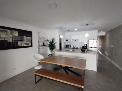 a kitchen and living room with a wooden table at Depa en Punta Hermosa in Punta Hermosa