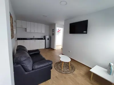 a living room with a leather couch and a table at Departamento de playa in Lima