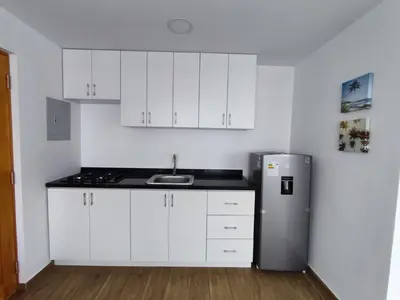 a kitchen with white cabinets and a stainless steel refrigerator at Departamento de playa in Lima
