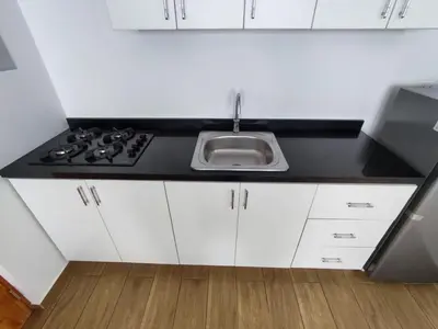 a kitchen with white cabinets and a sink at Departamento de playa in Lima